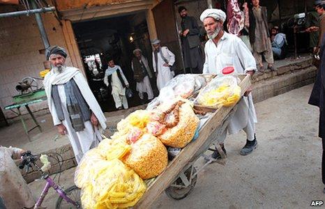 An Afghan vendor pushes his snack cart in a market in Lashkar Gah in March 2010
