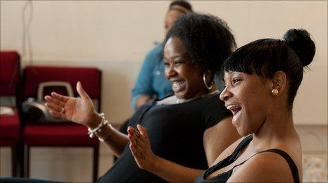 Two girls laugh during rehearsals at the Theatre Royal Stratford East