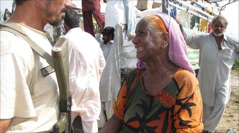 A woman pleads with a policeman to let her receive aid at a camp in Sukkur.