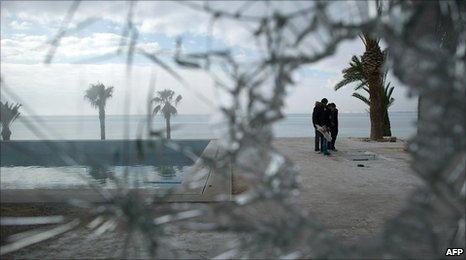 People standing next to the swimming pool at a looted house belonging to one of President Zine al-Abidine Ben Ali's nephews, 19 January 2010
