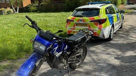 Off-road bike next to a Greater Manchester Police vehicle