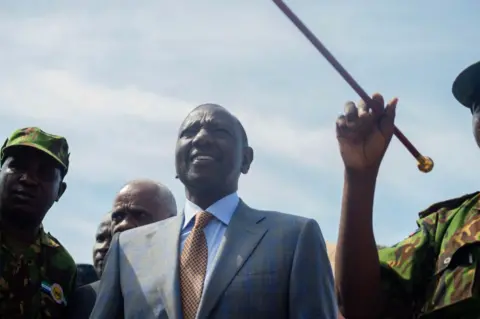 AFP Kenyan President William Ruto (C) arrives at the Toussaint Louverture International Airport in Port-au-Prince, Haiti on 21 September 2024