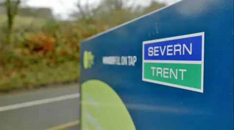 A Severn Trent motion   showing its bluish  and greenish  logo by the broadside  of the road