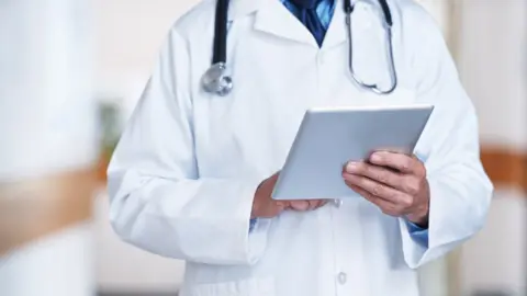 Getty Images Doctor checking patient records (generic image)