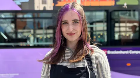 Caitlin Sneath in front of a Nottingham City Transport bus