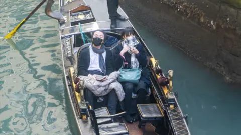 Getty Images Tourists wear protective facemasks as they visit Venice after the cancellation of the Venice Carnival festivities on February 24, 2020 in Venice, Italy. The final days of the carnival were cancelled due to the outbreak of the coronavirus COVID-19 in Italy, which has killed six people in the country.