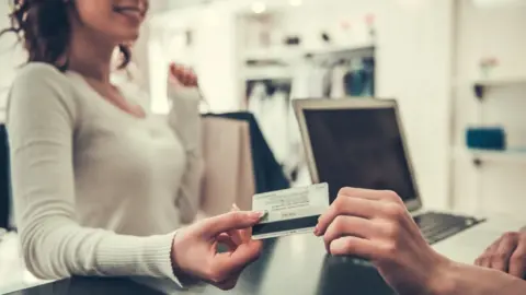 Getty Images Woman paying with card (generic)