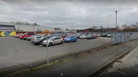 Google Car park full of cars behind grey metal fencing