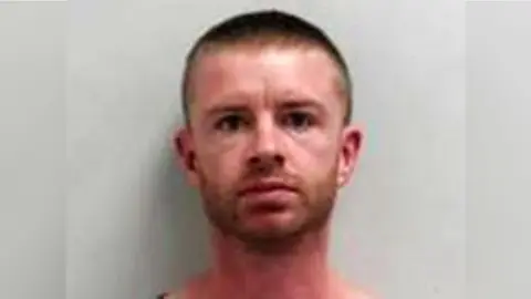 Mug shot of Kristopher Purvis - only his face and neck can be seen. He has light brown or ginger coloured hair and a beard, cut short. He has a neutral expression.