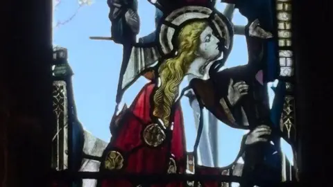 Close-up of a damaged stained glass window.