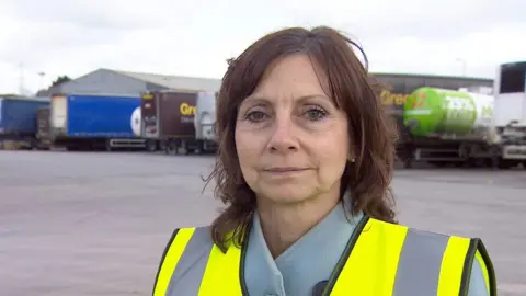 Angela Butler, Managing Director of Gregory Distribution. standing in front of lorries at their depot in Cullompton