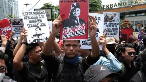 EPA Indonesian activists hold placards during a protest against the revision of the country's military law in front of the Parliament building in Jakarta on 20 March