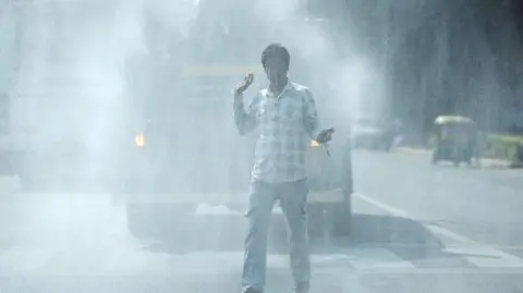 Getty Images A vehicle sprays water on the road for dust suppression in New Delhi, India, Tuesday