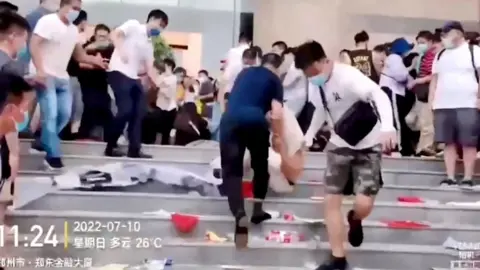 Reuters Security personnel dragging a protester down a flight of stairs.