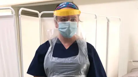 Dr Rachel Clarke dressed in scrubs, an apron and a protective mask as she worked on hospital wards throughout the covid pandemic