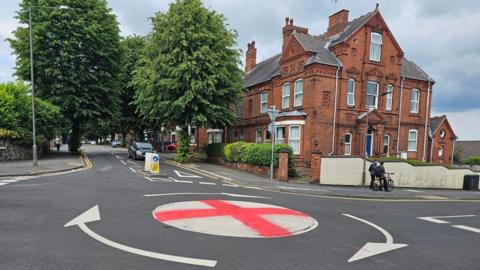 Mini roundabout on Park Road painted like the England flag