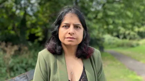 Susan Kohli wears a green blazer