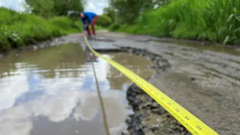 Wiltshire villagers left stranded by ' largest pothole'