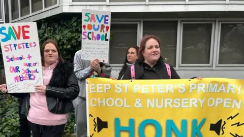 BBC Parents with signs protesting school closure