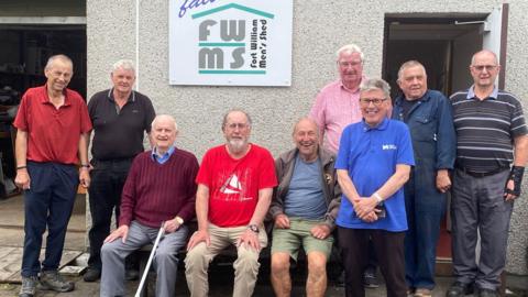 Group of men standing outside SMSA in Fort William