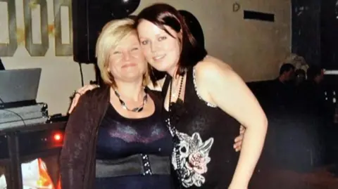 A mum and her daughter dressed up at a party, with their arms around each other