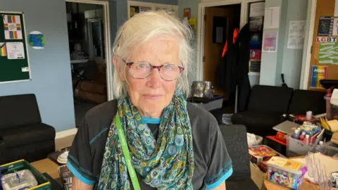 Councillor Liz Wright from Ashford Borough Council, Cabinet Member for Communities, Health and Wellbeing, stands inside Sk8side with board games and art materials packed into boxes ready to be removed