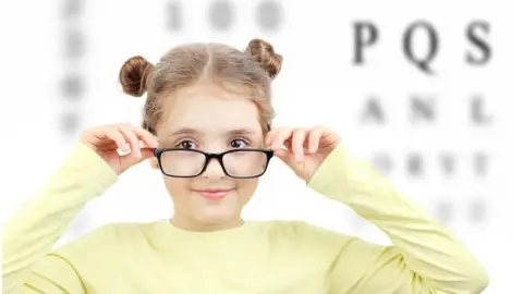 Getty Images Girl with glasses in front of letters