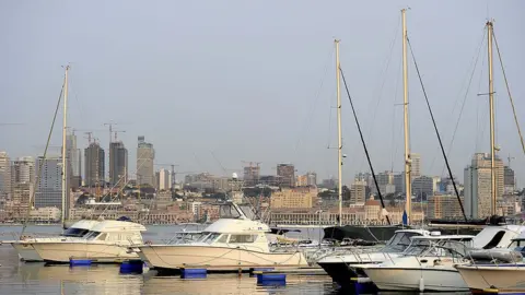 Getty Images Boats are docked in a marina with Luanda's skyline behind