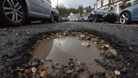 BBC A pothole in a suburban road