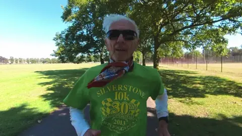 BBC Bob Emmerson is captured jogging in a park, wearing sunglasses and a green T-shirt