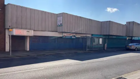 NELC A view of empty single-storey shops on Osborne Street, Grimsby