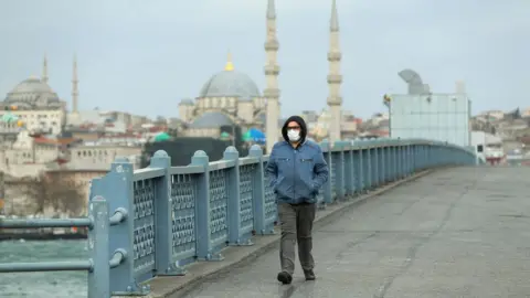 Getty Images A solitary man walks wearing a face mask