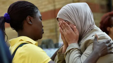 Reuters Women comforting each other