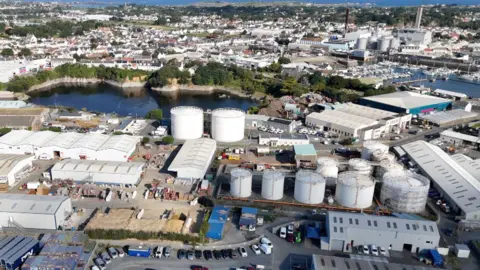 A drone's view of the Guernsey Gas gas holders. There are 11 large drums at the plant, which is close to a harbour.