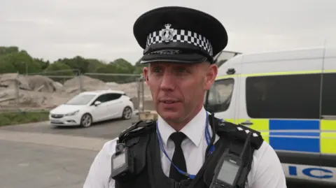 Chief Inspector Jason Bryant looking to the left. He is stood in front of the building site where the WW2 ordnance was detonated.