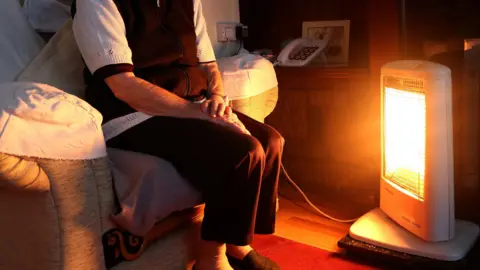 PA Media A generic stock photo of an elderly lady sitting at home with her electric fire on.