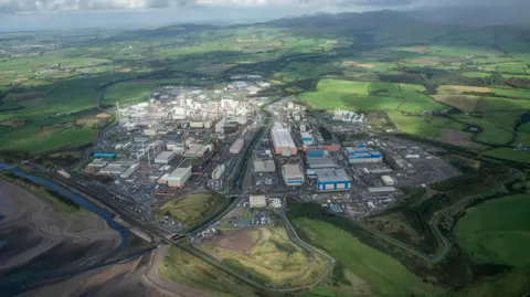 An aerial image of the Sellafield site. It looks like a very large industrial estate with dozens of buildings. It is surrounded by green fields.