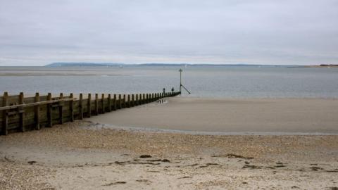 West Wittering beach at low tide. The sky is grey.