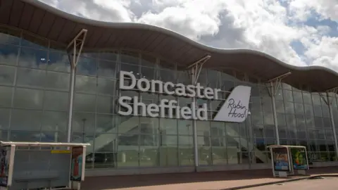 Getty Images The main entrance of Doncaster Sheffield Airport. It has a large glass front with its name in large writing. 