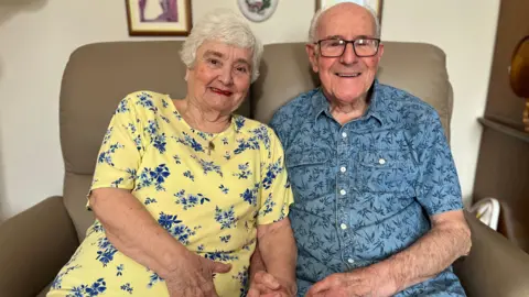 An older couple holding hands