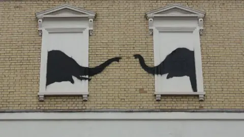 Banksy Two elephants stenciled on a house 