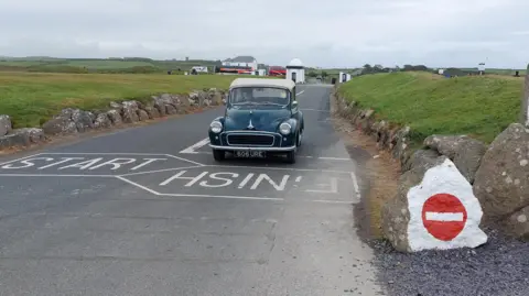 Handout A 1958 Morris Minor convertible arriving at Land's End