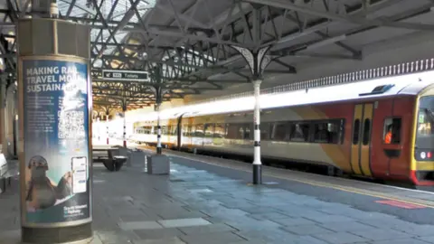 South Western Railway A view of a platform at Salisbury, with a metal column on the left and a train to the right