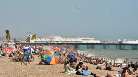 AFP People sunbathe on the beach at Brighton