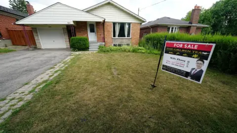 Reuters "For Sale" sign is pictured in the front yard of a house in Toronto, Ontario, Canada