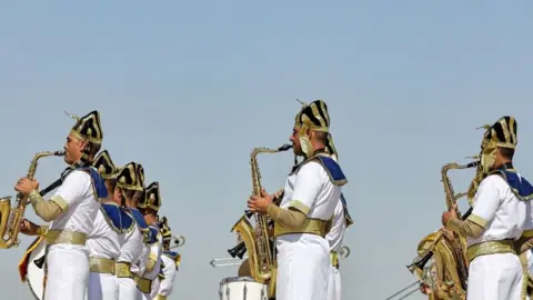 AFP A group of men playing the saxophone wearing ancient Egyptian clothes.