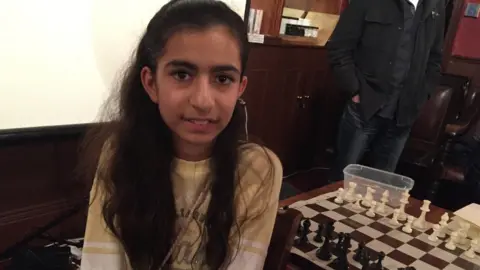 BBC Jiya next to chessboard