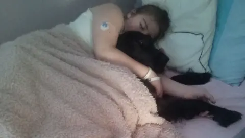 Kathy Johns Chloe Johns and a dog in a bed