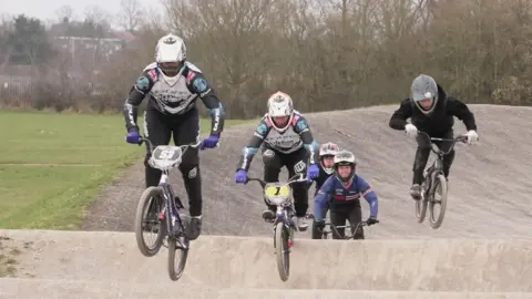 BBC/SHAUN WHITMORE Jared Hill leads four other riders over a jump on the Sloughbottom Park BMX track.