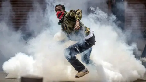 AFP Protesters react to tear gas launched by anti-riot police during an anti-government demonstration called following nationwide deadly protests over tax hikes and a controversial now-withdrawn tax bill in downtown Nairobi, on July 2, 2024.